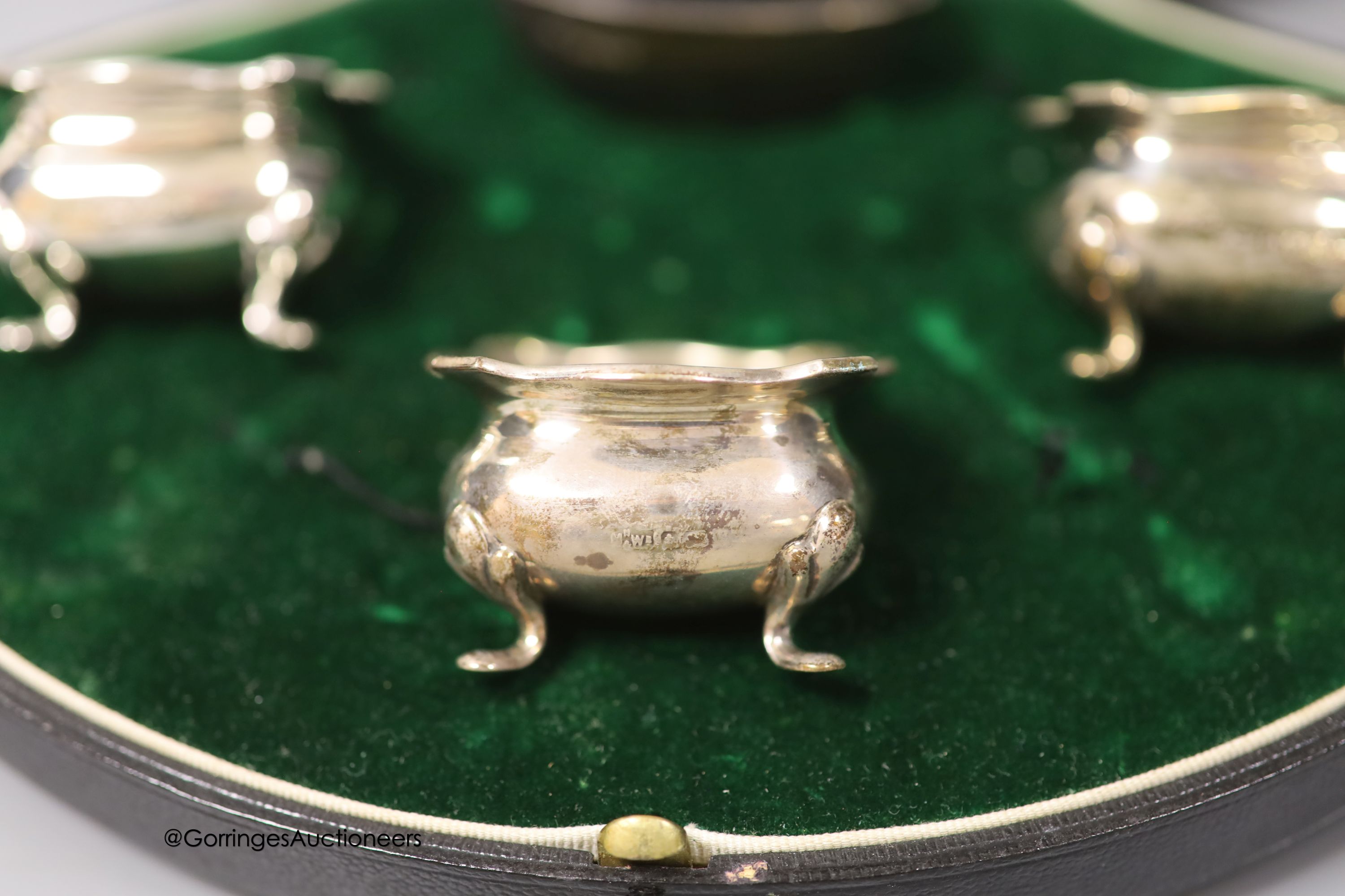 A cased pair of George V silver pepperettes, Mappin & Webb, London, 1913, 11.3cm and a cased harlequin four piece silver condiment set.